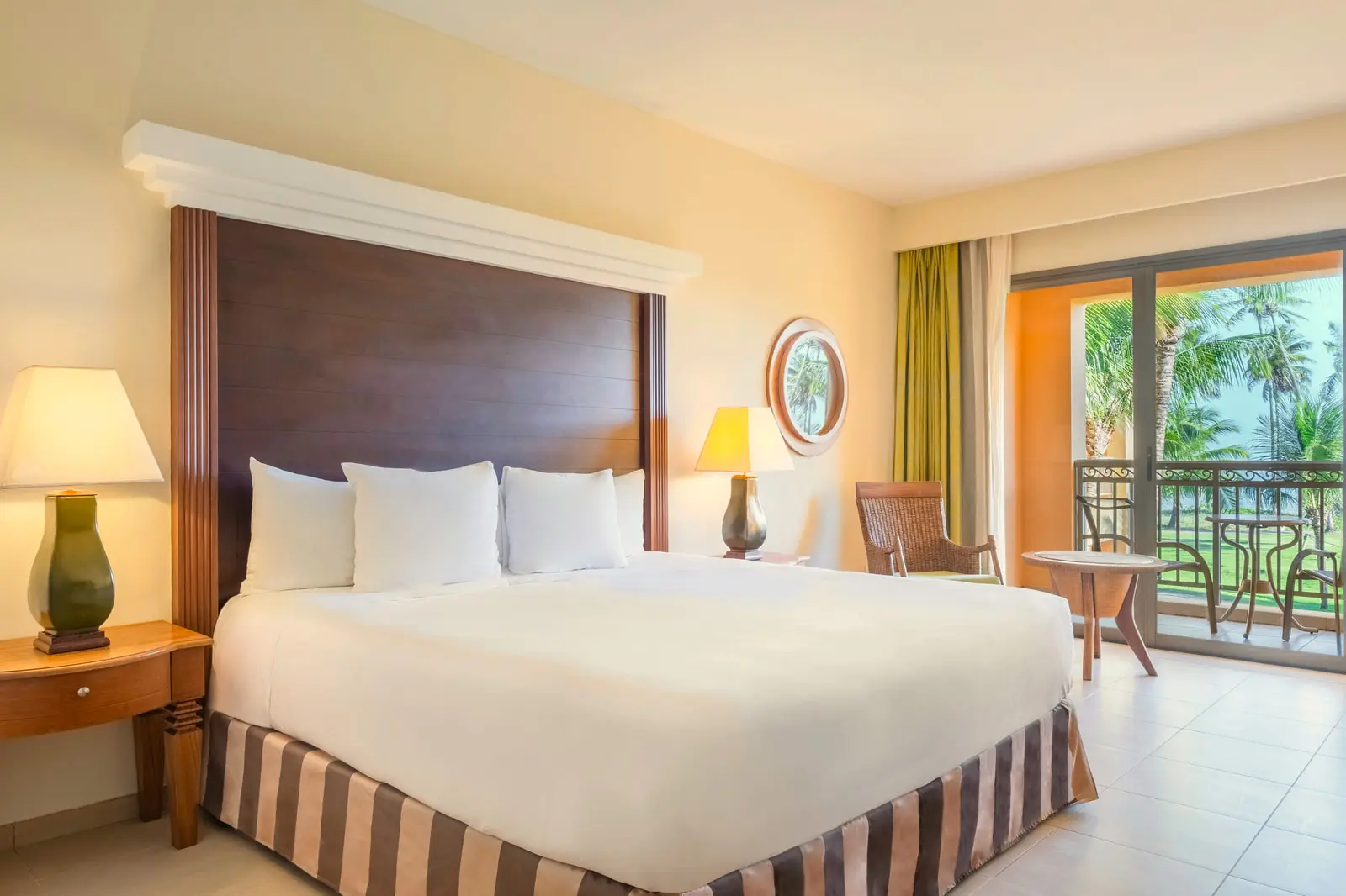 Quarto com cama king, abajures e varanda