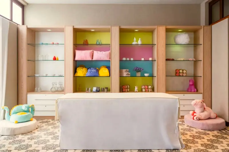 Spa infantil com maca baixa e prateleiras coloridas