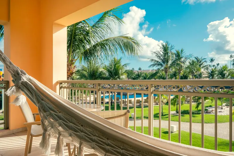 Varanda com rede e vista para o jardim e a piscina